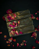 Black soap with rose clay swirl and dried rose petals on top, top view