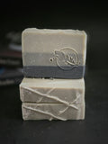 Soap bar that has stripes from gray (top) to black (bottom). 