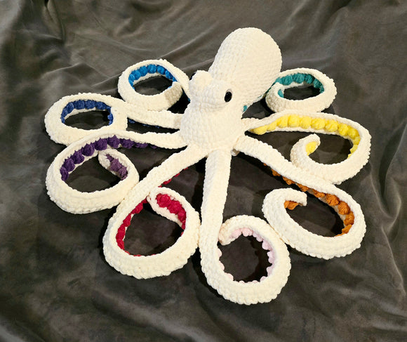 Cream color sparkly octopus with rainbow color suckers.